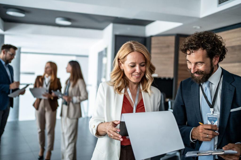 Two home builders compare notes at a home builder conference.