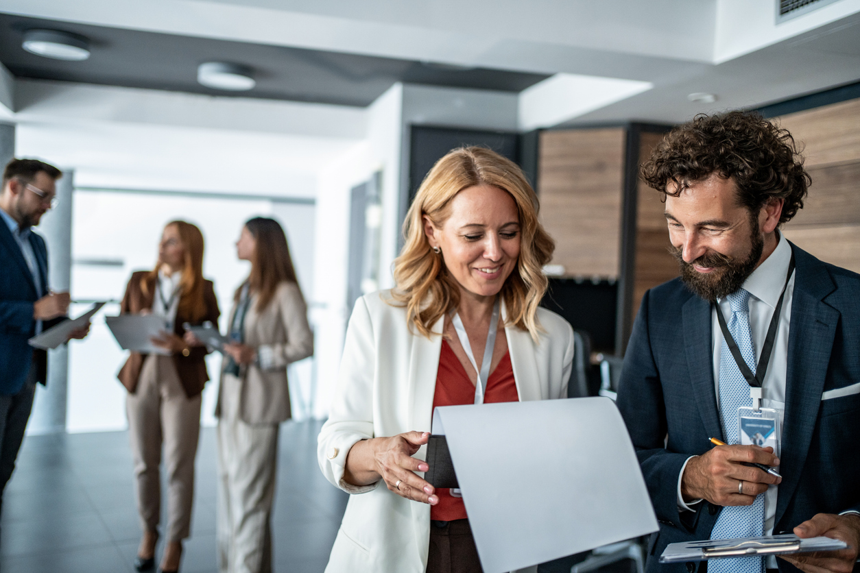Two home builders compare notes at a home builder conference.