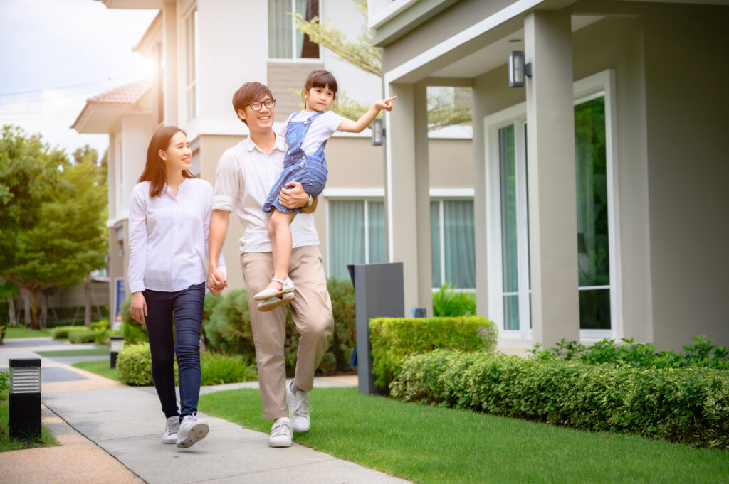 Asian family walks in front of new home purchased after using multilingual AI to converse with their homebuilder.